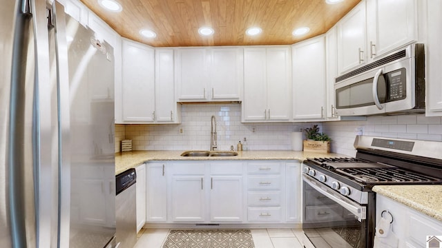 kitchen featuring white cabinets, stainless steel appliances, light stone counters, and sink