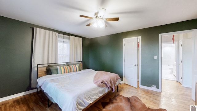 bedroom featuring hardwood / wood-style flooring, ceiling fan, and ensuite bath