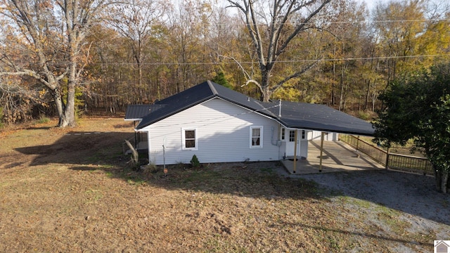 view of home's exterior featuring a yard and a carport