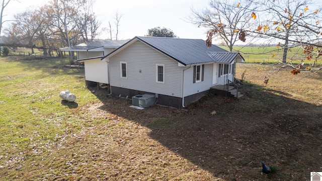 view of property exterior featuring central air condition unit and a lawn