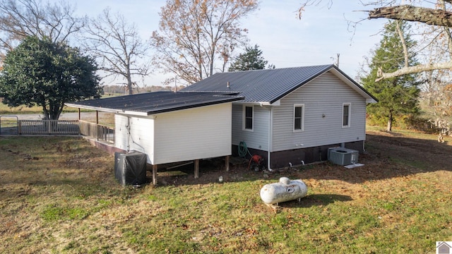 rear view of house with a lawn and central air condition unit