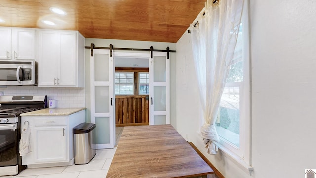 kitchen featuring a barn door, white cabinetry, appliances with stainless steel finishes, and wooden ceiling