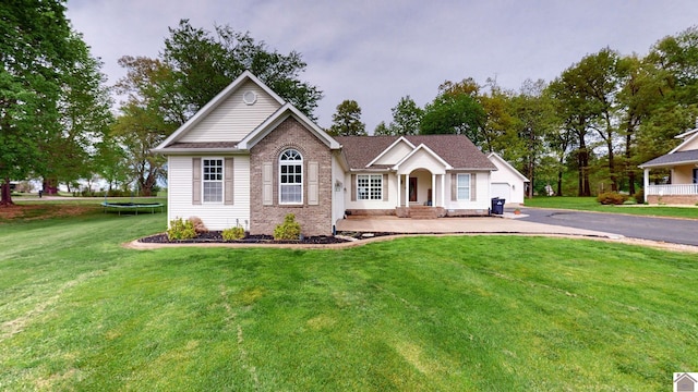 view of front of house featuring a garage, a trampoline, and a front yard