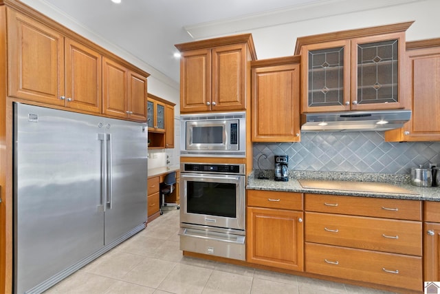 kitchen with built in appliances, ornamental molding, tasteful backsplash, light tile patterned flooring, and light stone counters