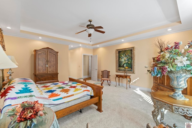 carpeted bedroom with ceiling fan, ornamental molding, and a tray ceiling