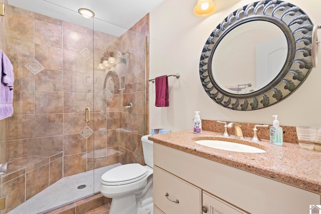 bathroom with vanity, toilet, and a shower with shower door