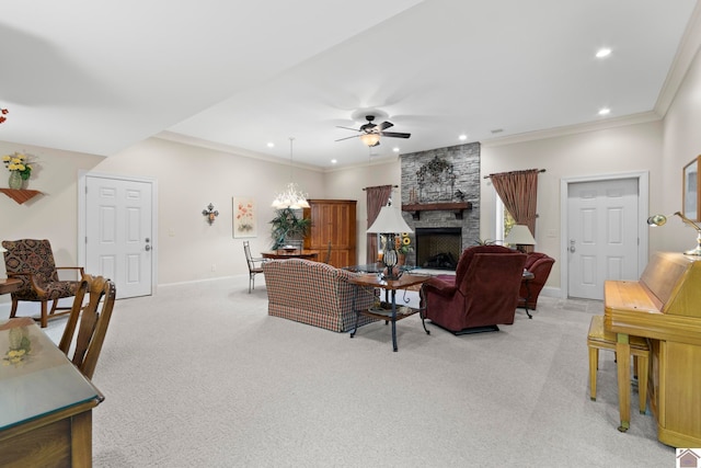 living room with a fireplace, ceiling fan with notable chandelier, light colored carpet, and crown molding