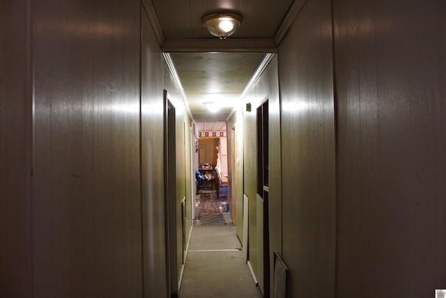 corridor with wooden walls and crown molding