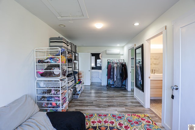 spacious closet with a wall mounted AC and hardwood / wood-style floors