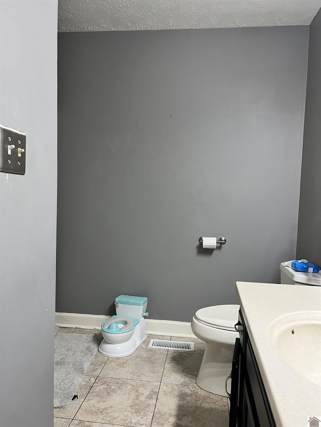 210 Banberry Bnd, Paducah, KY 42001 - bathroom with tile patterned flooring, vanity, toilet, and a textured ceiling