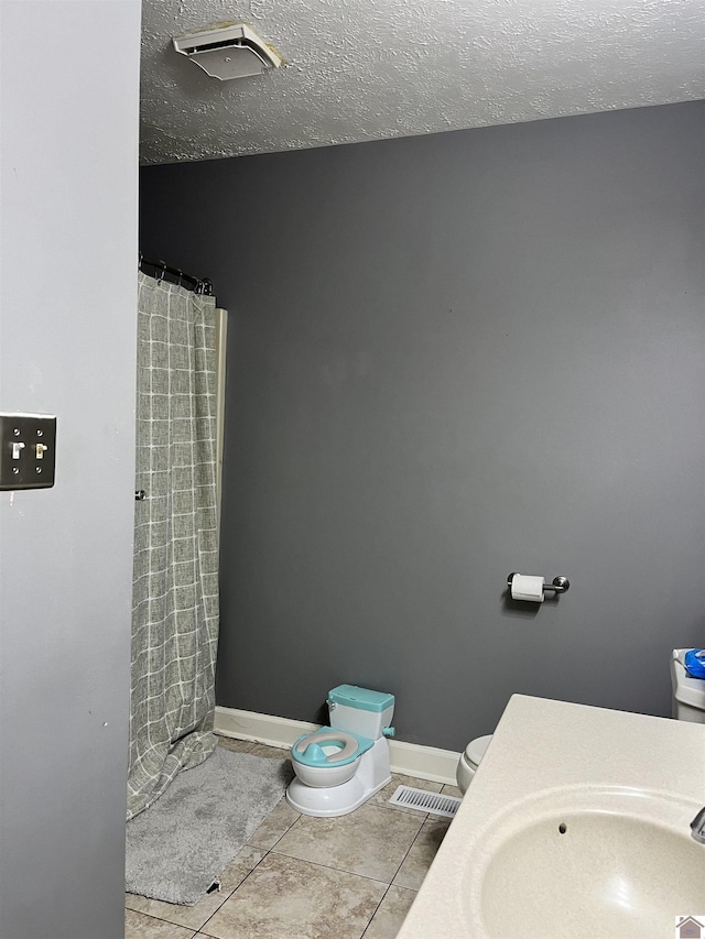 210 Banberry Bnd, Paducah, KY 42001 - bathroom featuring toilet, a textured ceiling, tile patterned floors, and sink