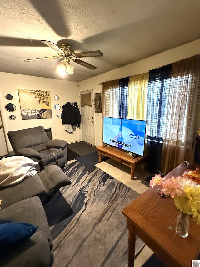 living room with ceiling fan and a textured ceiling