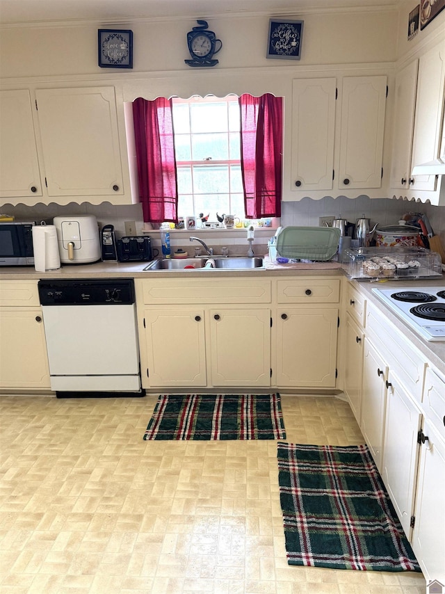 kitchen featuring sink, white cabinets, and white appliances