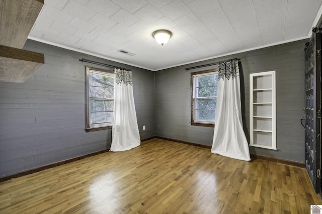 unfurnished room with hardwood / wood-style flooring and plenty of natural light