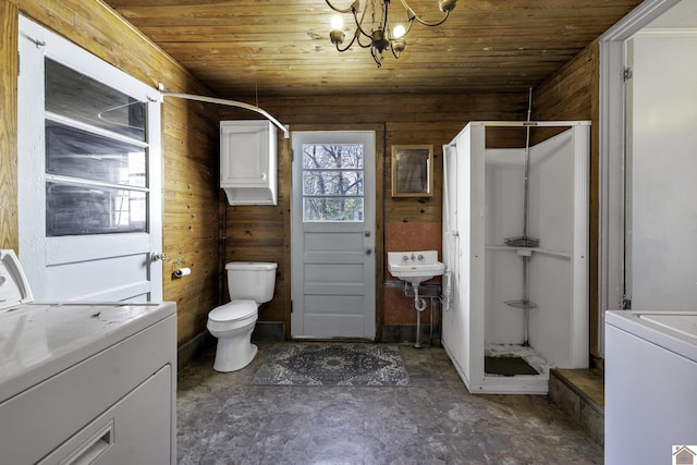 bathroom featuring washer / dryer, toilet, wooden walls, and wood ceiling