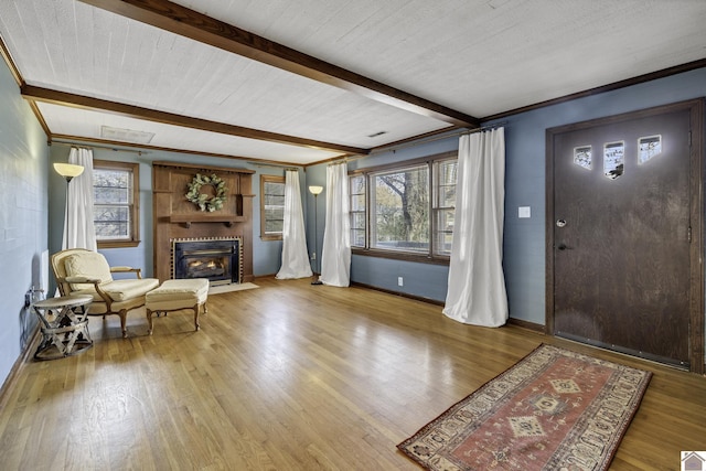 entrance foyer featuring hardwood / wood-style flooring, a healthy amount of sunlight, and beam ceiling