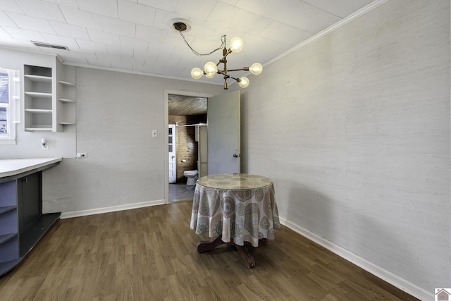 dining area with a notable chandelier, crown molding, and dark wood-type flooring