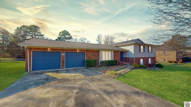 155 County Line Rd, Paducah, KY 42003 - tri-level home featuring brick siding, concrete driveway, an attached garage, and a lawn