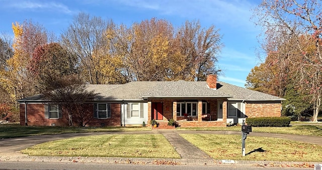 ranch-style home featuring covered porch and a front yard