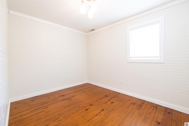 unfurnished room featuring hardwood / wood-style floors and ornamental molding