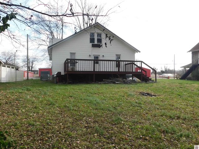 rear view of house with a deck and a yard