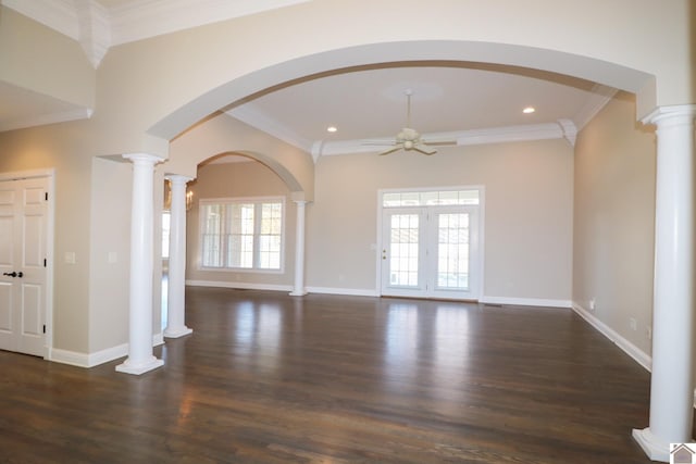 empty room featuring dark hardwood / wood-style floors, a healthy amount of sunlight, ceiling fan, and decorative columns