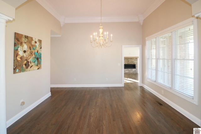 interior space featuring a notable chandelier, a fireplace, dark hardwood / wood-style floors, and ornamental molding