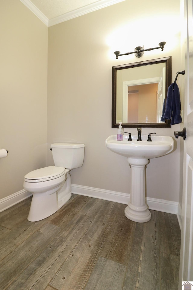 bathroom featuring wood-type flooring, toilet, and ornamental molding