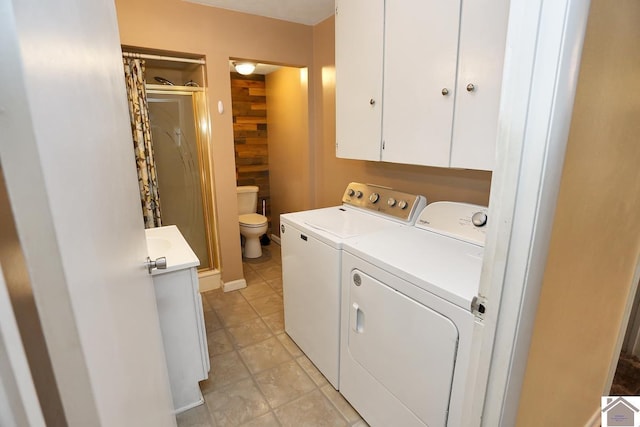 clothes washing area with wooden walls, light tile patterned floors, and independent washer and dryer