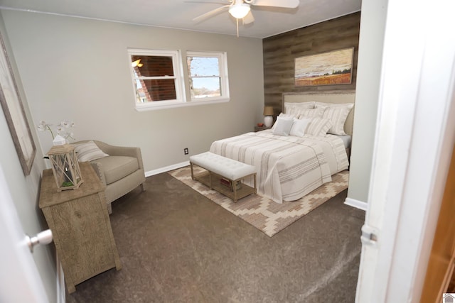 bedroom featuring dark colored carpet, ceiling fan, and wooden walls