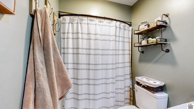 bathroom featuring a shower with shower curtain and toilet