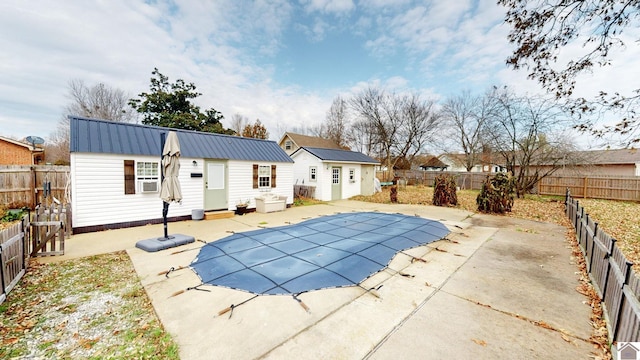 view of pool with a patio, cooling unit, and an outdoor structure