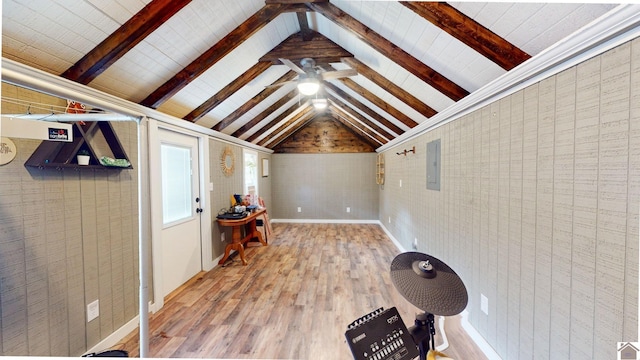 additional living space featuring hardwood / wood-style floors, lofted ceiling with beams, and electric panel