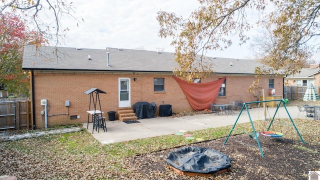 rear view of house with a playground and a patio