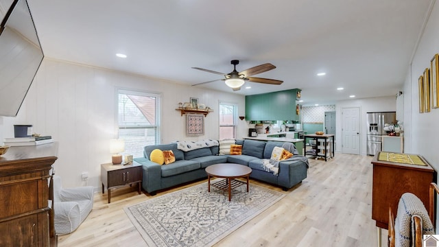 living room with light hardwood / wood-style flooring and ceiling fan