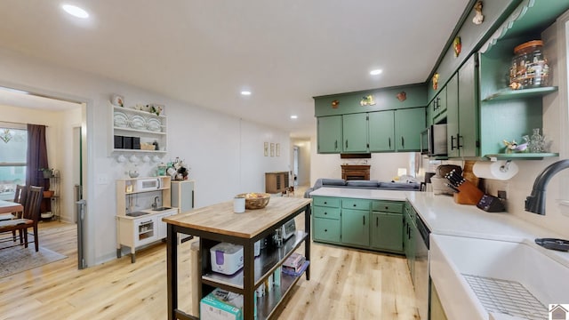 kitchen featuring green cabinets, sink, and light wood-type flooring