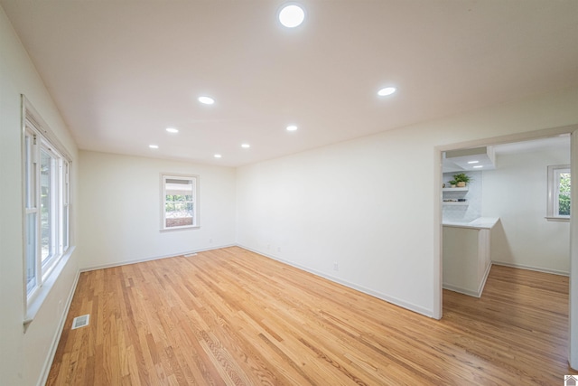 empty room with light hardwood / wood-style flooring and plenty of natural light