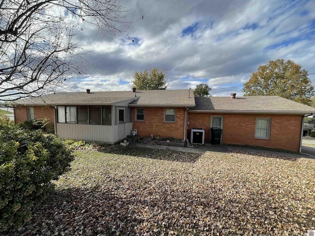 back of property with a sunroom and central AC unit