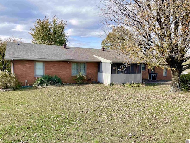 ranch-style house featuring a sunroom and a front yard