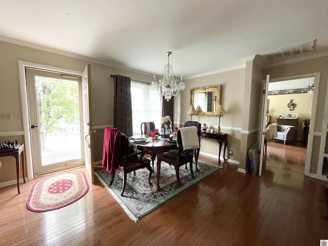 dining space featuring a chandelier, ornamental molding, and dark wood-type flooring