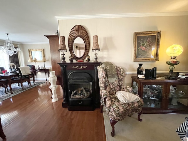 living area with a fireplace, dark hardwood / wood-style flooring, ornamental molding, and an inviting chandelier