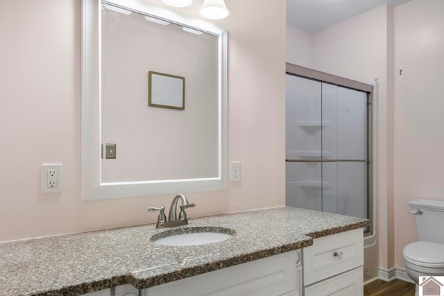 bathroom featuring vanity, hardwood / wood-style flooring, and toilet