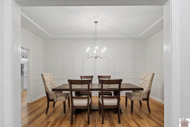 dining room with ornamental molding, a chandelier, and light wood-type flooring