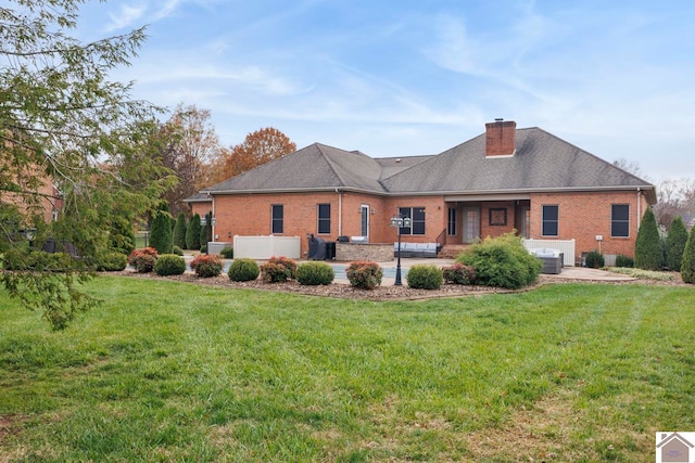 rear view of property featuring a patio, central air condition unit, and a lawn