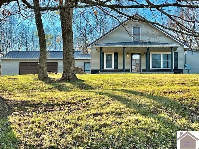 view of front of house featuring an outbuilding, a front yard, and a garage