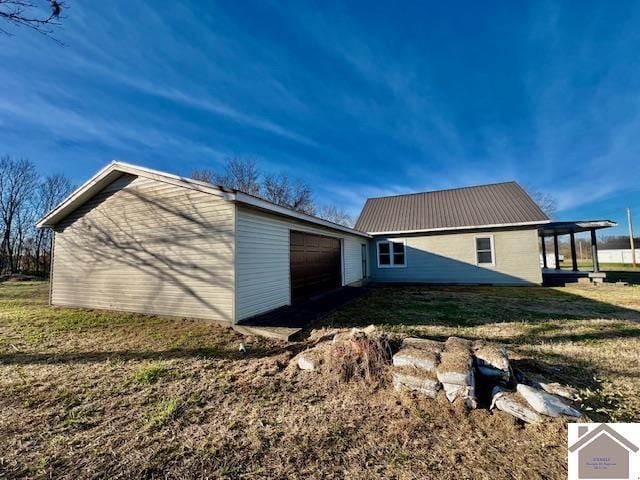 view of side of property featuring a lawn and a garage