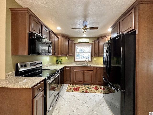 kitchen featuring a textured ceiling, ceiling fan, sink, black appliances, and light tile patterned floors