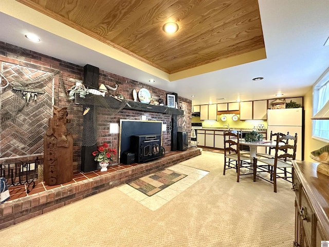 living room with a raised ceiling, a wood stove, wood ceiling, and brick wall