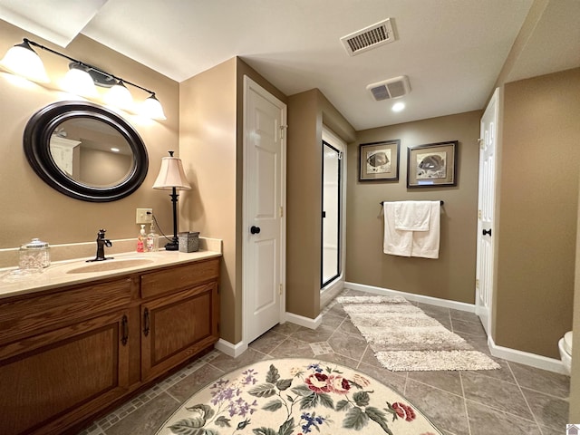 bathroom with tile patterned flooring, vanity, and an enclosed shower