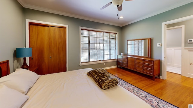 bedroom featuring wood-type flooring, a closet, ceiling fan, and crown molding